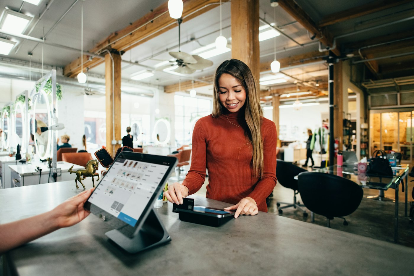 Customer paying at a cafe counter with a card reader